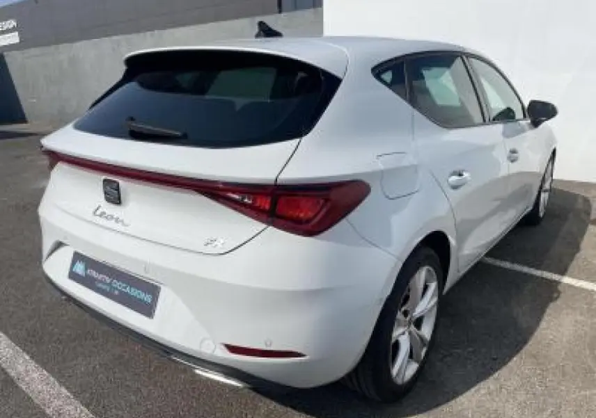 SEAT Leon blanc Nevada vue 3/4 arrière droit, avec feux arrière reliés et jantes alliage 17 pouces.