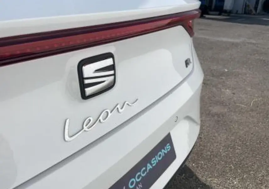 Gros plan sur l'arrière blanc Nevada d'une SEAT Leon IV avec logo et feu arrière continu lumineux rouge.