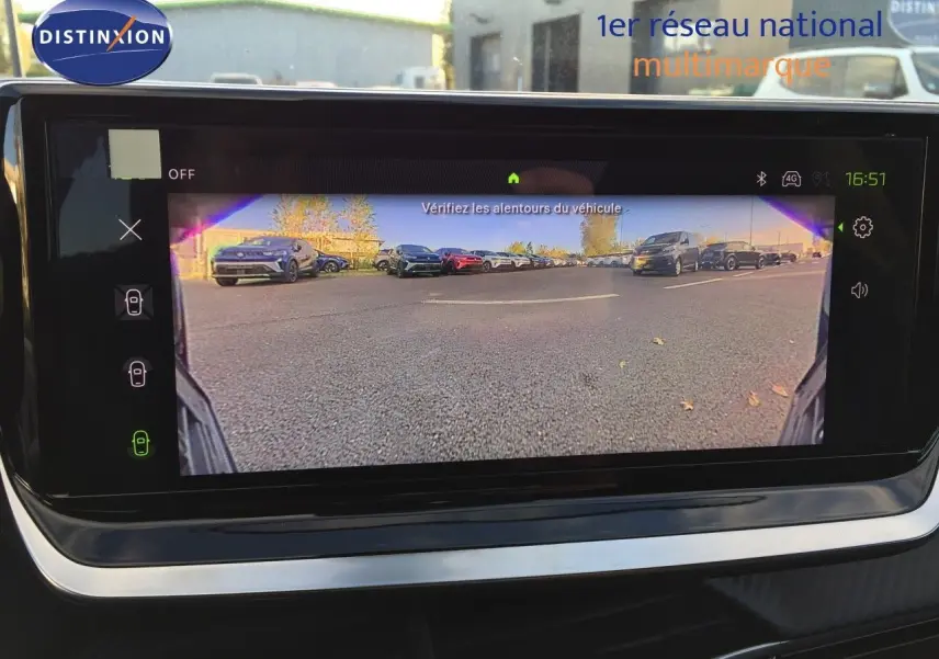 Vue de la caméra de recul affichée sur l'écran intérieur d'une Peugeot 208 gris Artense, montrant le parking derrière.