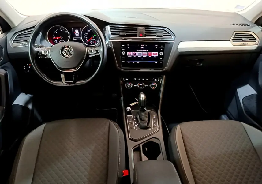 Intérieur Volkswagen Tiguan 2020 vu de face, tableau de bord noir avec écran tactile et volant cuir multifonctions.