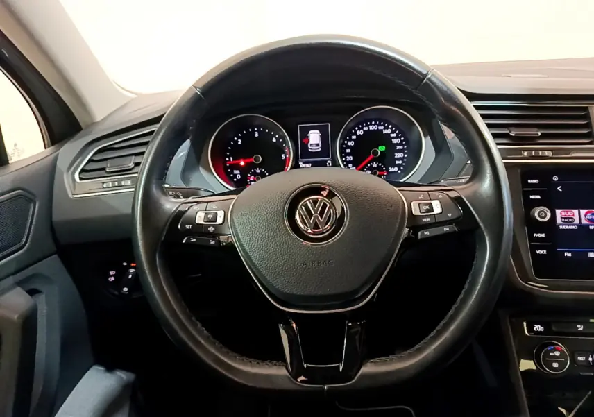 Vue intérieure centrée sur le volant cuir noir et le tableau de bord digital du Volkswagen Tiguan gris clair 2020.