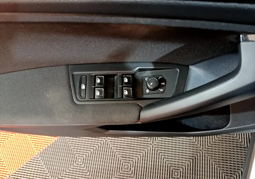 Panneau de porte côté gauche du Volkswagen Tiguan gris clair 2020 avec commandes électriques des vitres et réglage des rétroviseurs.