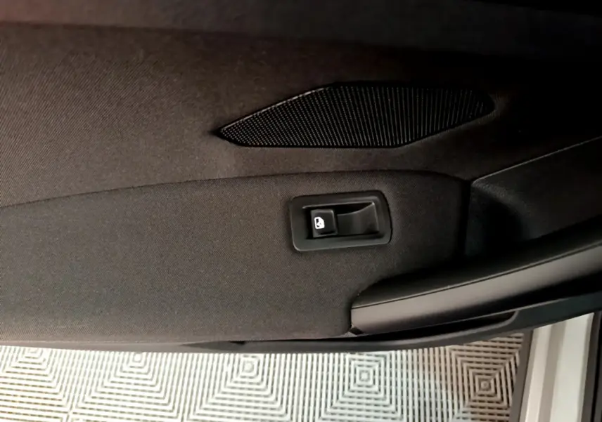 Détail de la poignée intérieure de porte arrière droite du Volkswagen Tiguan gris clair 2020.