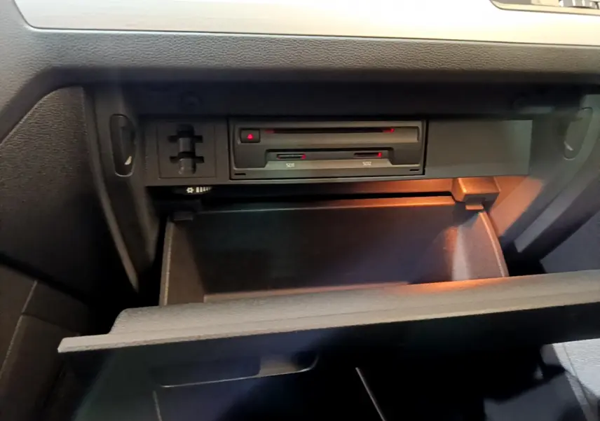 Gros plan sur la boîte à gants ouverte du Volkswagen Tiguan gris clair, montrant les lecteurs de cartes SD intégrés.
