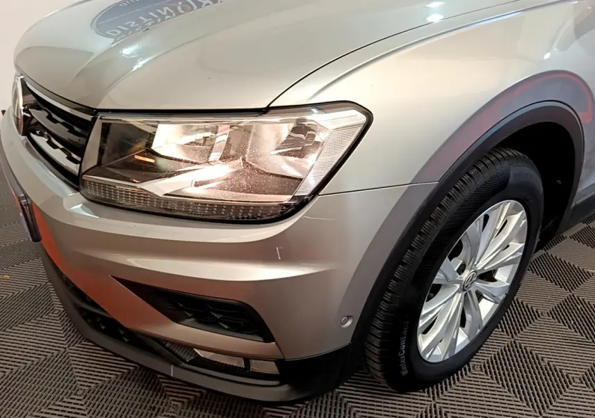 Gros plan sur l'avant droit du Volkswagen Tiguan gris clair 2020, mettant en valeur son phare LED et la jante alliage.