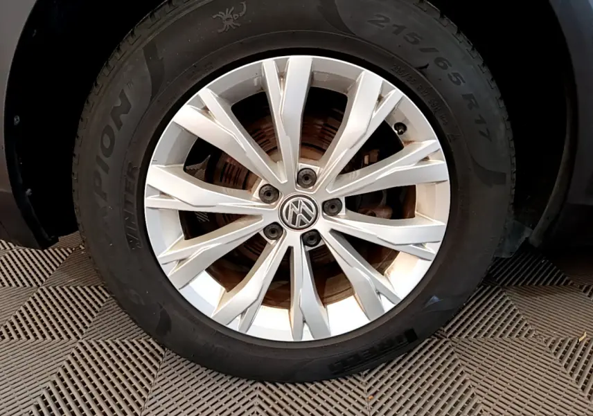 Gros plan sur la jante argentée et le pneu hiver Pirelli d'un Volkswagen Tiguan gris clair 2020.