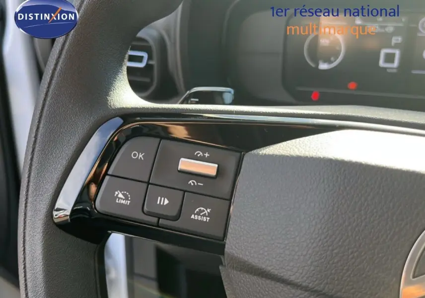 Gros plan sur les commandes au volant côté gauche du Citroën Berlingo blanc Icy 2025 avec régulateur et limiteur de vitesse.