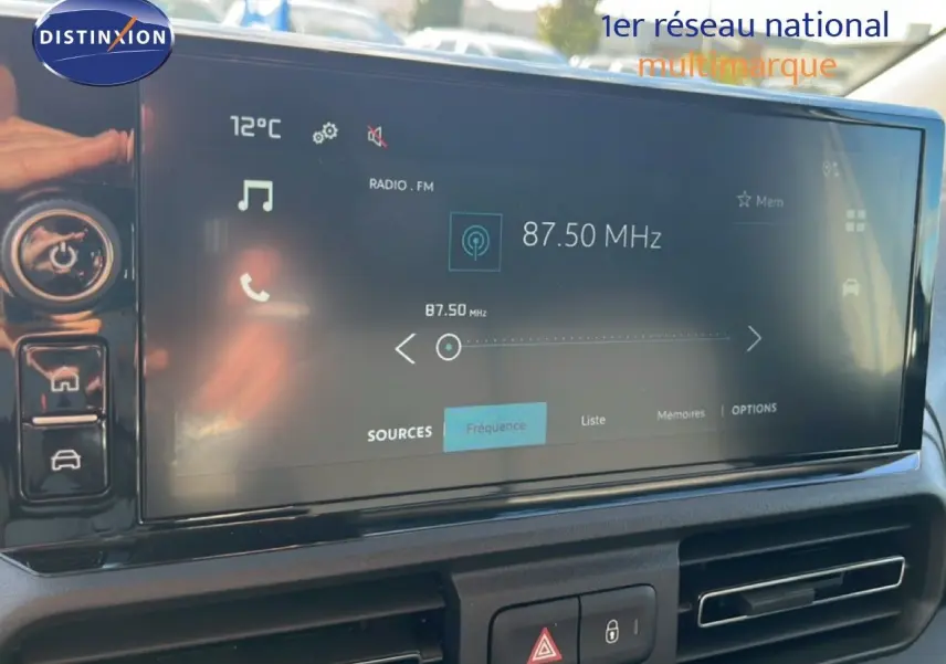 Écran tactile central du tableau de bord du Citroën Berlingo blanc Icy, affichant la radio FM à 87,50 MHz.