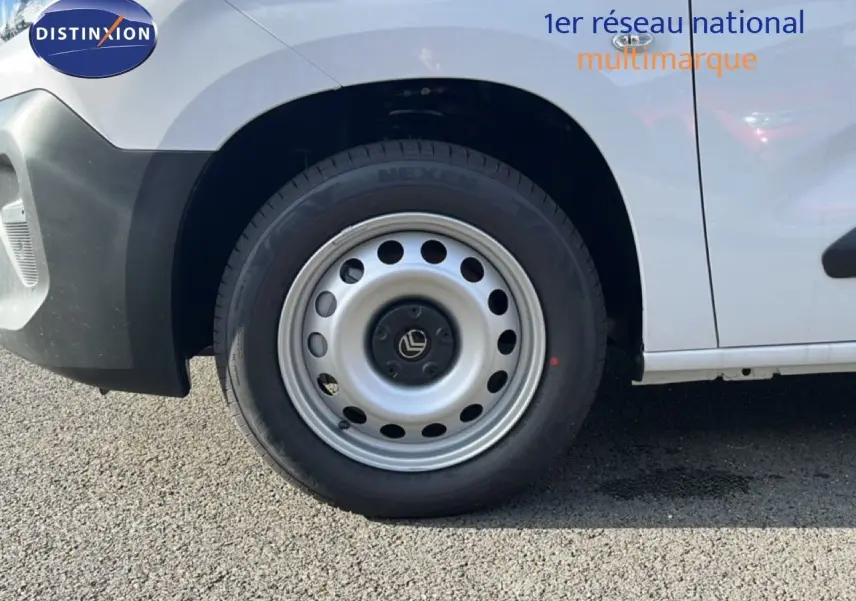 Gros plan sur la roue avant gauche d’un Citroën Berlingo blanc Icy, avec jante acier et partie basse noire.