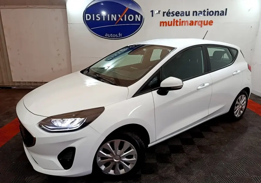 Vue 3/4 avant droite d'une Ford Fiesta blanche 2022 avec phares LED et jantes alliage dans un showroom.