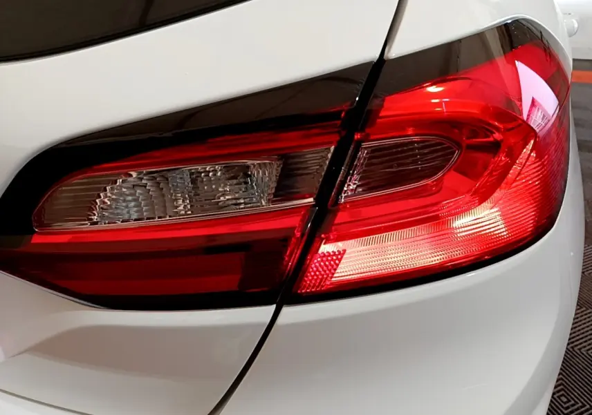 Gros plan sur le feu arrière droit rouge et blanc d'une Ford Fiesta blanche, version 2022, essence.