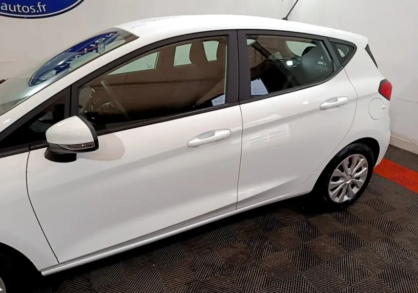 Vue de profil côté gauche d'une Ford Fiesta blanche 2022 avec rétroviseur et poignées assortis.