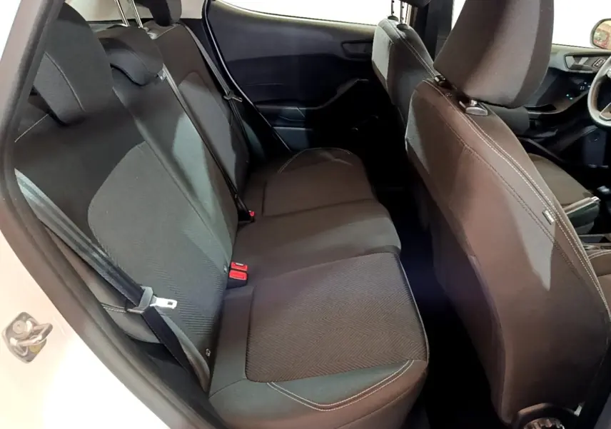 Vue intérieure côté gauche montrant la banquette arrière noire de la Ford Fiesta blanche 2022, avec sièges et ceintures visibles.