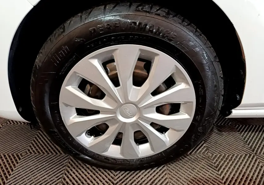 Gros plan sur la roue avant gauche blanche d'une Ford Fiesta 1.1 75ch COOL & CONNECT avec jante argentée.