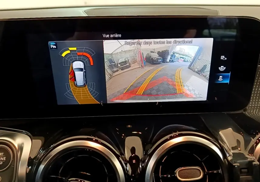 Écran tactile intérieur du Mercedes GLB 200 d 2021 affichant la caméra de recul et l’aide au stationnement.