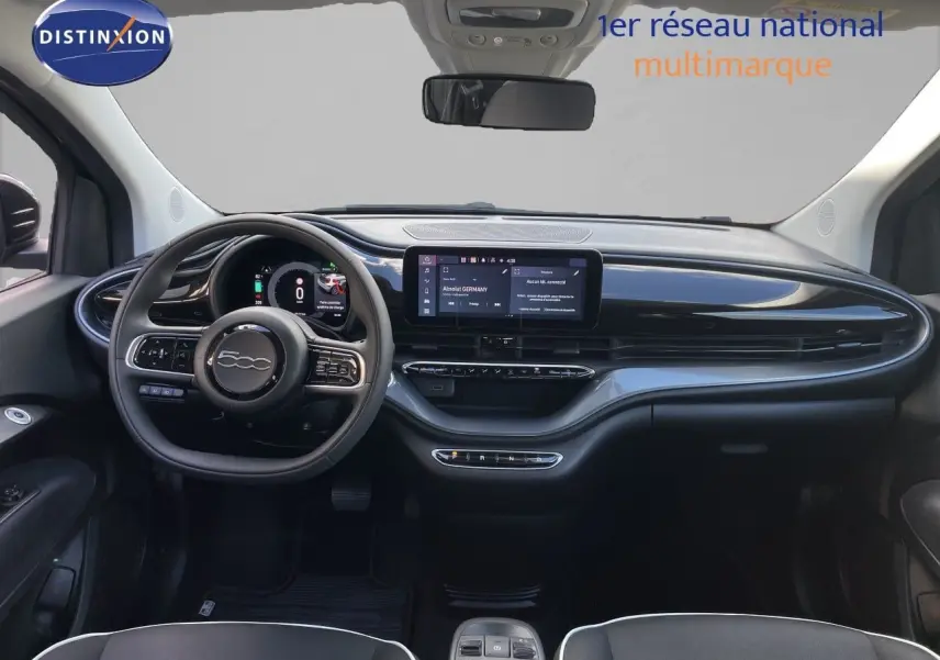 Tableau de bord noir brillant de la Fiat 500 électrique 2023, vue frontale centrée sur le volant et l’écran tactile.