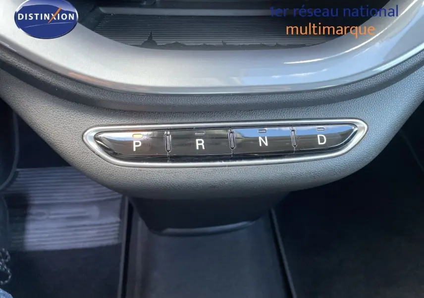 Gros plan sur la commande de boîte automatique avec boutons P, R, N, D dans l’habitacle noir d’une Fiat 500 électrique 2023.