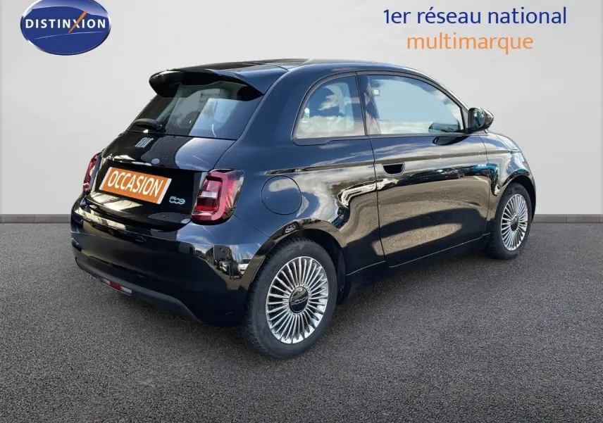 Vue 3/4 arrière droite d'une FIAT 500 électrique 2023 noir Onyx avec jantes spécifiques et feux arrière LED.