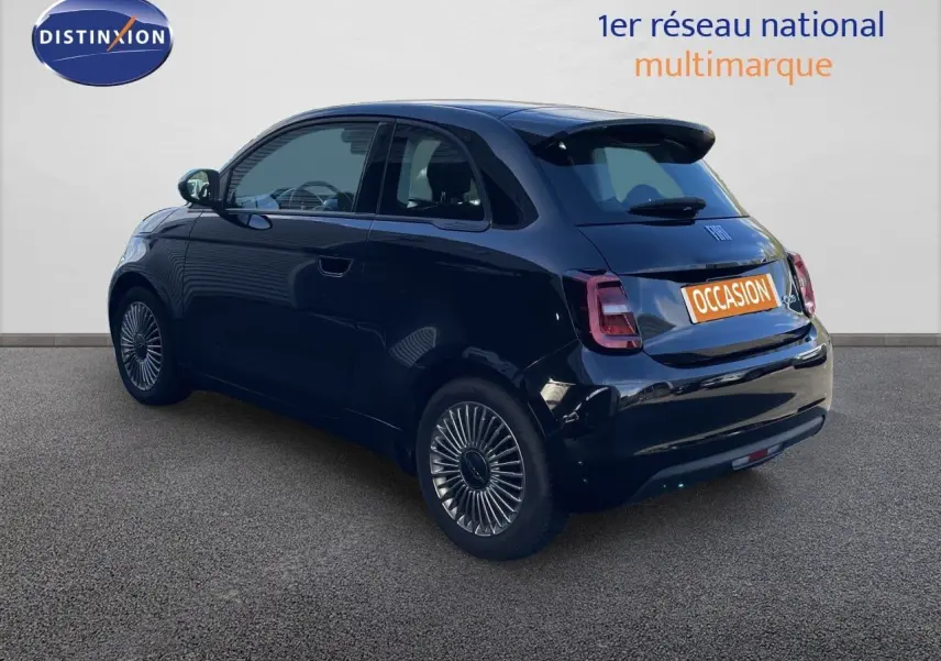 Vue 3/4 arrière droite d'une Fiat 500 électrique 2023 noir onyx avec jantes spécifiques et toit noir brillant.