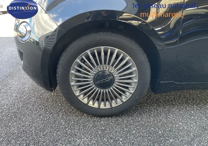 Gros plan sur la roue avant gauche de la FIAT 500 électrique 2023 noir onyx avec jante alliage distinctive.