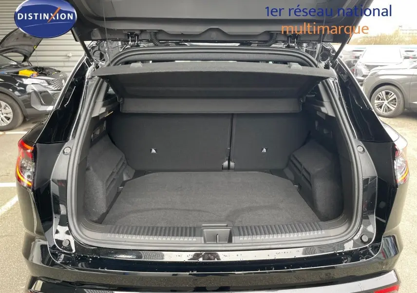 Coffre ouvert vu de l'arrière d'un Renault Austral noir étoile métal, montrant un espace de chargement spacieux et propre.