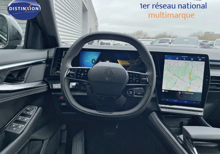 Intérieur du Renault Austral E-Tech 2025 vu du poste de conduite, volant cuir noir et écran tactile avec navigation affichée.