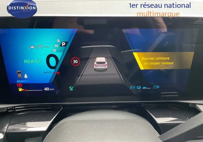 Tableau de bord numérique du Renault Austral E-Tech noir, affichant la vitesse et alertes de sécurité en conduite.