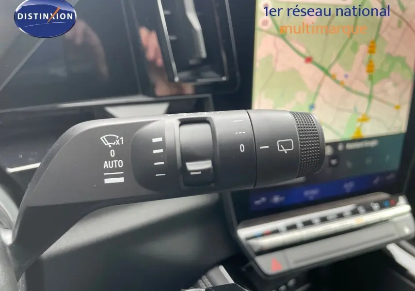 Gros plan sur la commande d'essuie-glace du Renault Austral noir étoile métal avec écran tactile et GPS en arrière-plan.