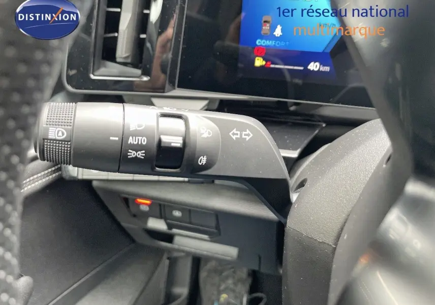 Gros plan sur la commande des phares et clignotants à gauche du volant dans le tableau de bord noir du Renault Austral 2025.