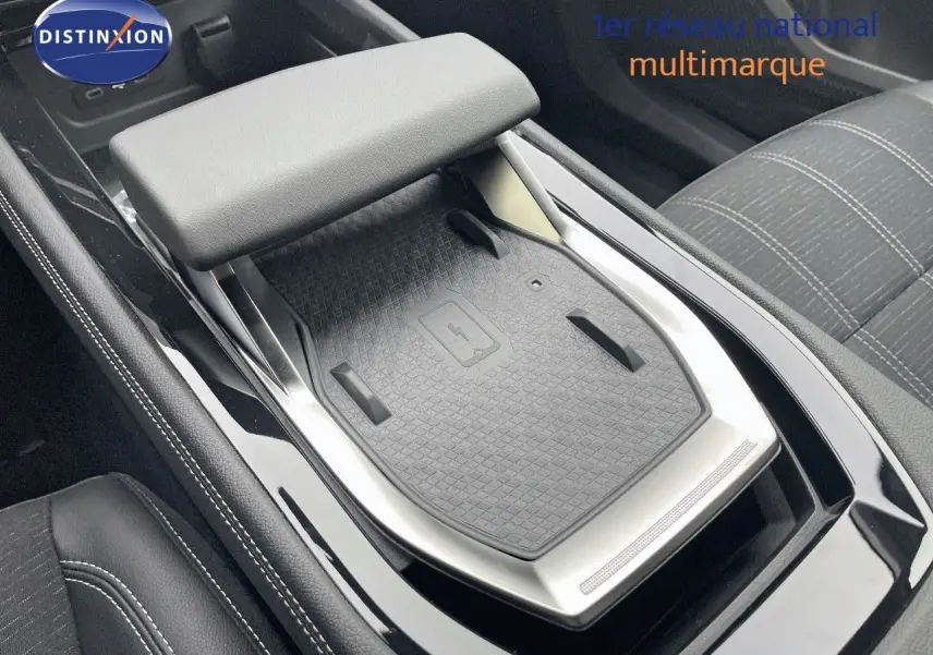 Vue rapprochée de la console centrale noire du Renault Austral E-Tech Hybrid 2025 avec surface de charge sans fil.