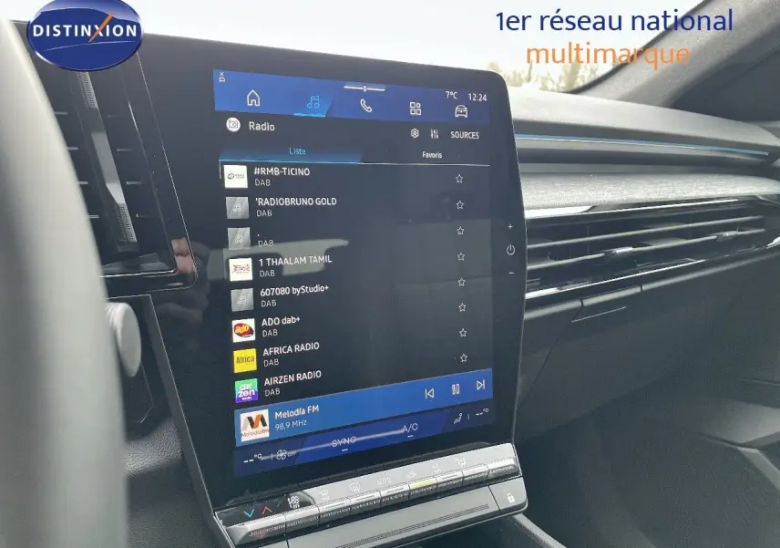 Vue intérieure centrée sur l'écran tactile du tableau de bord du Renault Austral noir étoile métal, affichant la radio numérique.