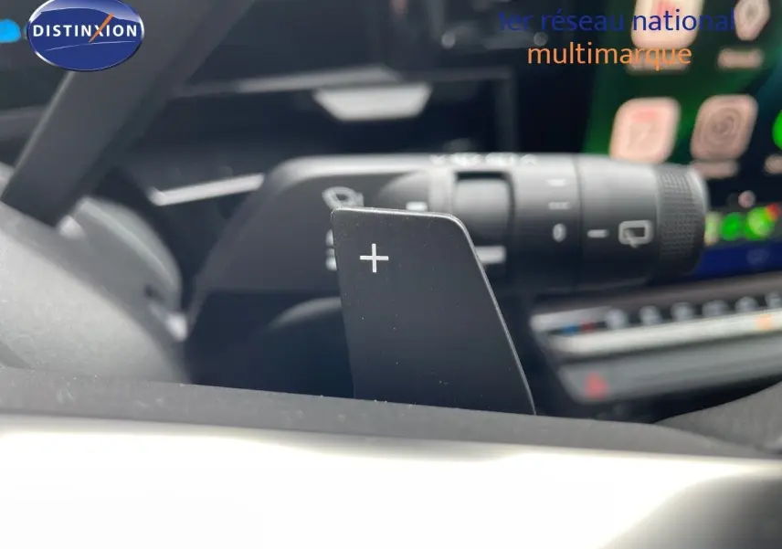 Gros plan sur la palette de changement de vitesse "+" du volant d'un Renault Austral noir étoile métal, intérieur moderne.