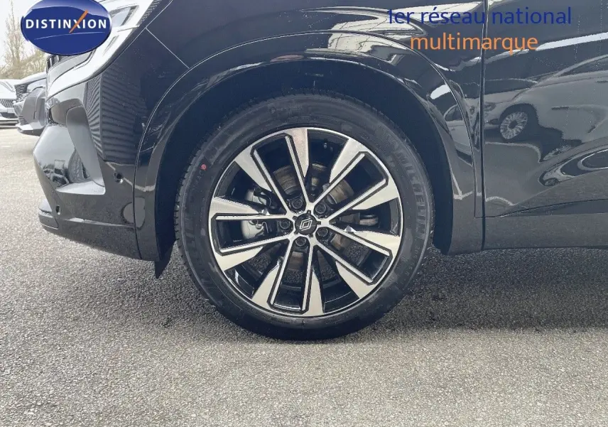 Gros plan sur la roue avant gauche du Renault Austral noir étoile métal avec jante alliage bicolore design moderne.