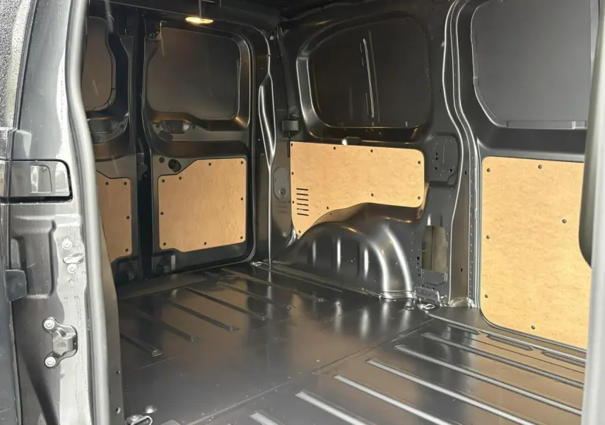 Vue intérieure de la zone de chargement du Citroën Jumpy gris titane, avec panneaux en bois et métal nu.