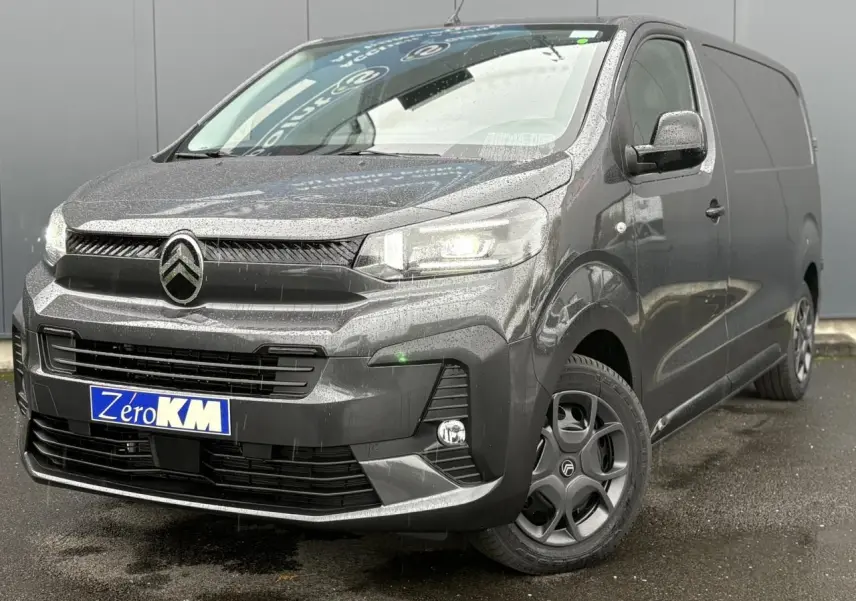 Citroën Jumpy gris titane en 3/4 avant droit sous la pluie avec phares Full LED allumés et jantes noires.