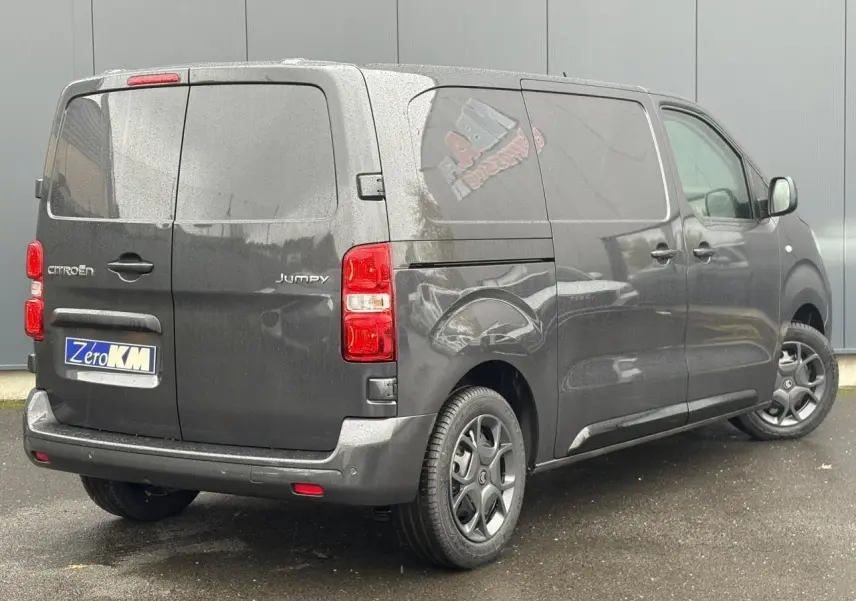 Vue 3/4 arrière droite d'un Citroën Jumpy gris titane avec portes arrière battantes et jantes noires.