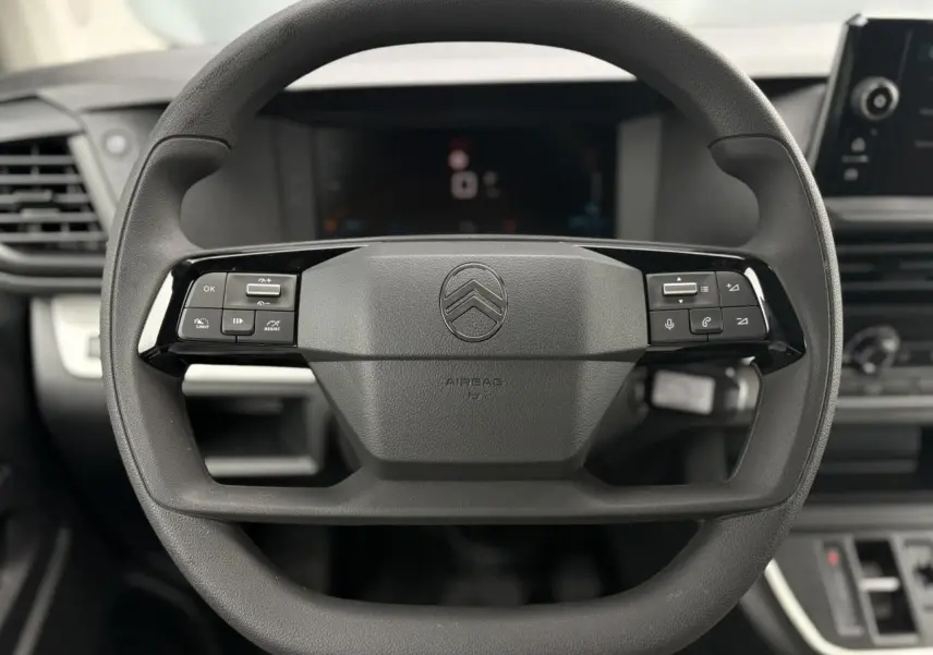 Gros plan sur le volant multifonction noir du Citroën Jumpy 2025 avec commandes intégrées et logo central visible.