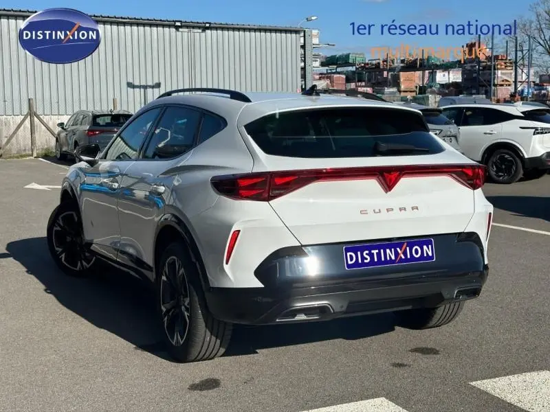 Vue 3/4 arrière droite du CUPRA Formentor blanc Nevada métallisé avec feux arrière en bandeau lumineux distinctif.