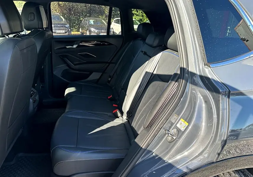 Vue intérieure côté droit des sièges arrière en cuir noir avec surpiqûres bleues du Volkswagen Tiguan gris dauphin 2024.