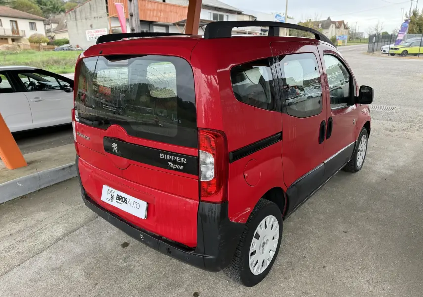 Vue 3/4 arrière droite d'un Peugeot Bipper Tepee rouge avec portes coulissantes et jantes blanches.