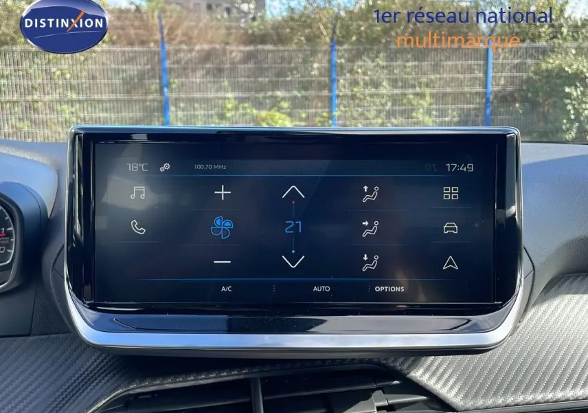 Écran tactile central affichant la climatisation dans l'habitacle d'une Peugeot 2008 blanche vue de face.