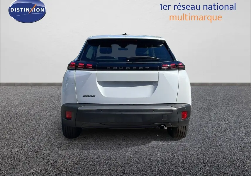 Vue arrière d'un Peugeot 2008 blanc Okenite Metal avec feux LED et hayon fermé sur sol gris.
