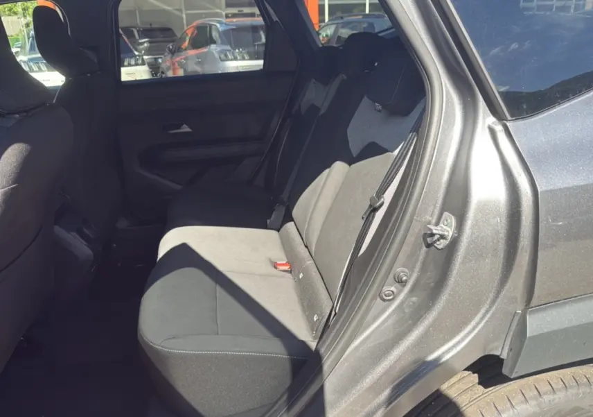 Vue côté gauche arrière du Dacia Bigster gris schiste, mettant en valeur la banquette arrière et l'ouverture de porte.