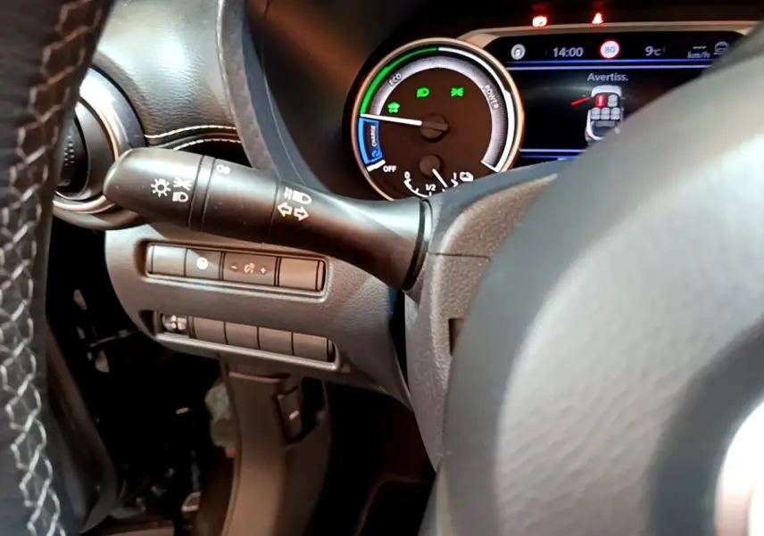 Gros plan sur le tableau de bord et le combiné d'instruments du Nissan Juke Hybrid noir, avec affichage digital et commandes au volant.