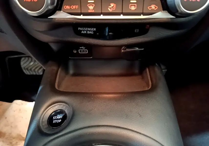 Vue rapprochée du bouton Start Stop noir sur la console centrale en cuir noir du Nissan Juke Hybrid 2022.
