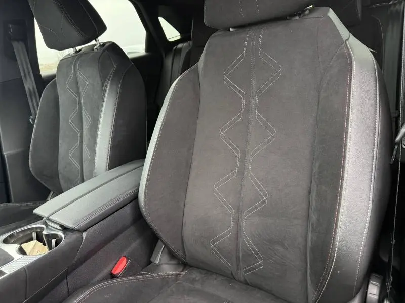 Gros plan sur les sièges avant en cuir noir avec surpiqûres géométriques du DS7 E-TENSE 2024, intérieur élégant.