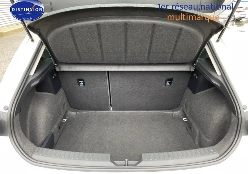 Coffre ouvert d'une SEAT LEON blanche 2024, vue de l'arrière montrant un espace de chargement propre et spacieux.