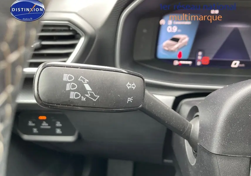 Le commodo de clignotants et feux du SEAT Leon IV visible en gros plan côté gauche du volant, tableau de bord en arrière-plan.