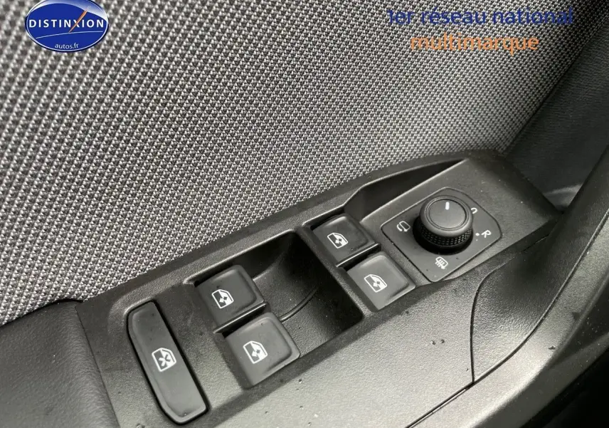 Panneau de commandes des vitres et rétroviseurs côté conducteur d'une SEAT Leon blanche 2024, intérieur tissu gris.