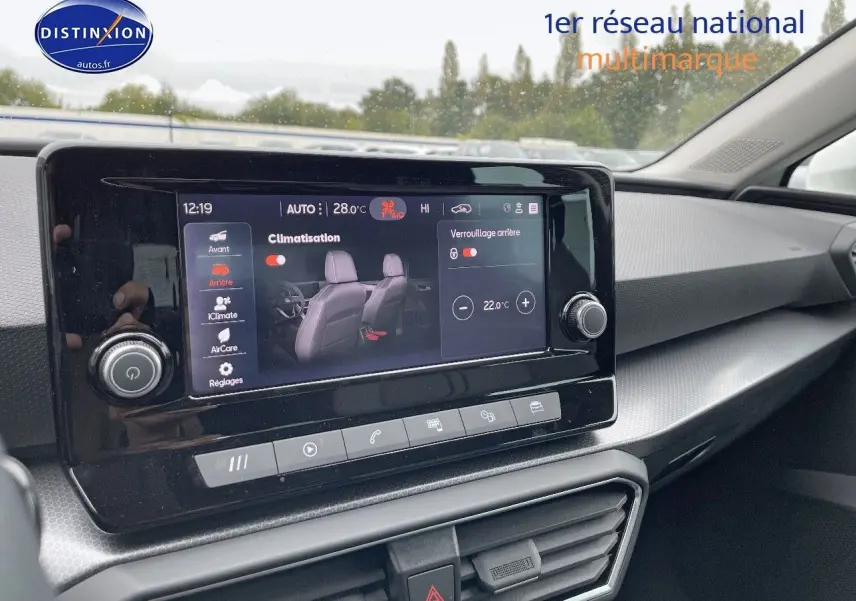 Écran tactile central affichant la climatisation dans l'habitacle moderne d'une SEAT LEON blanche, vue côté passager.